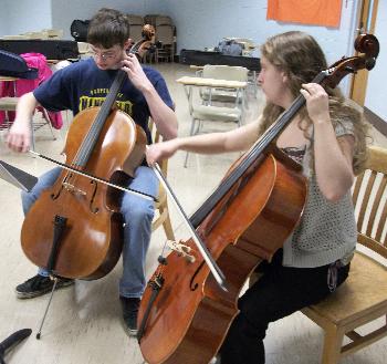 Student teaching another student cello